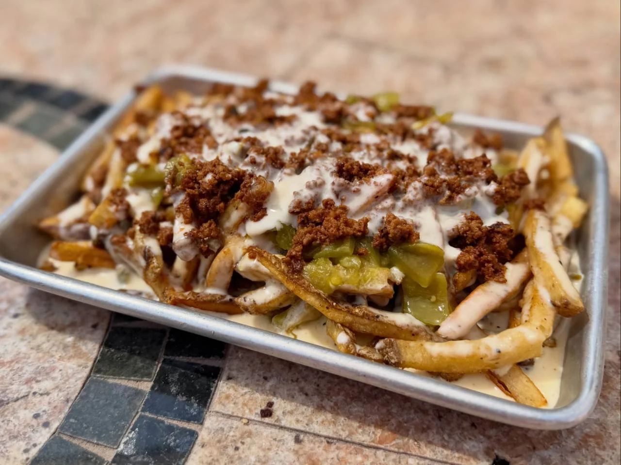 A seasonal Victory Tap tray of loaded fries topped with Hatch chiles, chorizo and queso.