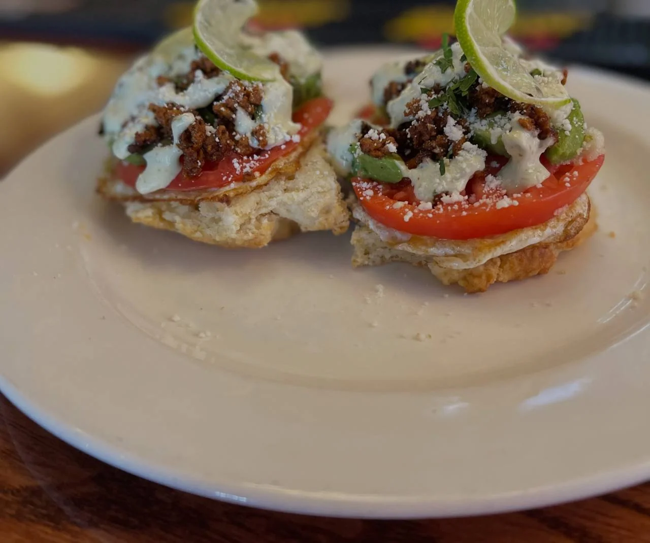 A past Victory Tap savory brunch special with tomato, avocado, sauce, crumbled toppings and fresh lime.