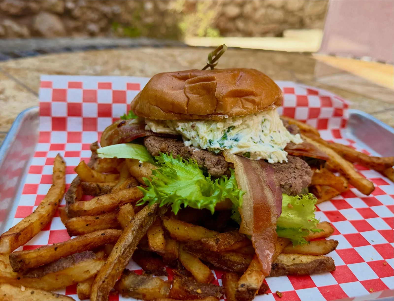 The Bougie Burger — bacon and herbed cream cheese on a toasted bun, hand-cut fries