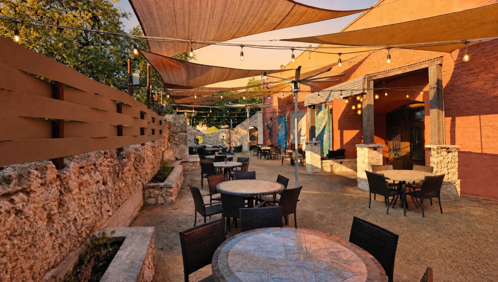 The patio at golden hour, warm light across the tables